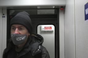 A passenger in a medical mask on a Skoda electric train