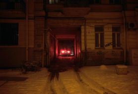 The light from the headlights of the car in the arch of the building