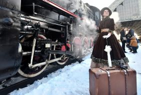 Girl in retro style clothes near the retro train