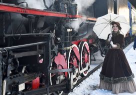 Girl in retro style clothes near the retro train