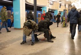 Homeless people sleep on a bench at one of the stations of the Kyiv metro