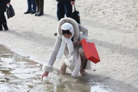 A woman collects water from the Dnieper in a jar