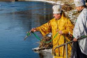 Священнослужители освящают воду в реке Уж