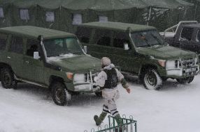 A serviceman near a military SUV