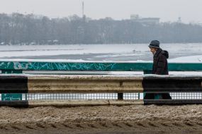 A woman walks across a snowy transport bridge
