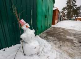 Snowman near metal garages