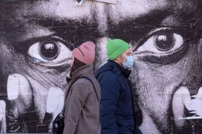 People walk past the banner