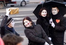 Mimes in the image of lovers under an umbrella