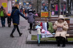 Elderly woman sells knitwear