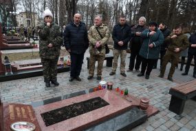 ATO participants and volunteers pray at the grave of ATO participant Hryhoriy Semanyshyn