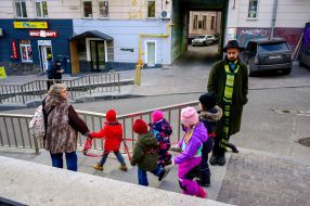 The tutor leads the children holding the rope down the street