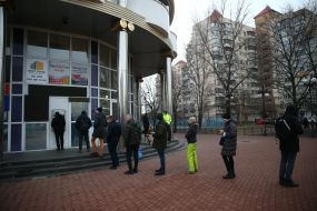 People stand in line at the ATM