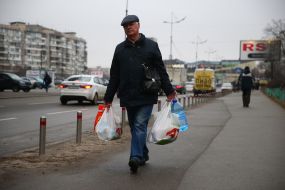 The man carries bags of groceries
