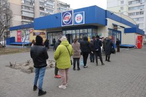 People stand in line at the ATM