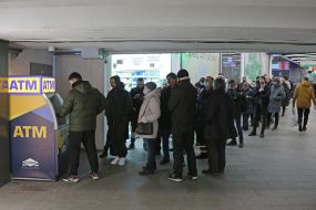 People stand in line at the ATM