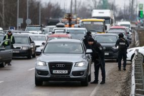 Law enforcement officers check the documents of drivers