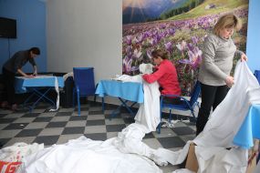 Women cut fabric for camouflage suits