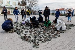 People weave camouflage nets on the square in Uzhgorod