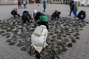 People weave camouflage nets on the square in Uzhgorod