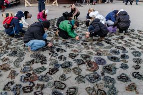 People weave camouflage nets on the square in Uzhgorod