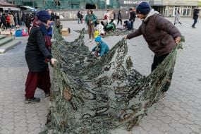 People weave camouflage nets on the square in Uzhgorod