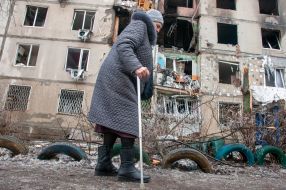 An elderly woman near a house destroyed in the shelling by the Russian military occupiers in a residential area of Kharkiv