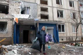 Woman near a house destroyed in the shelling by the Russian military occupiers in a residential area of Kharkiv