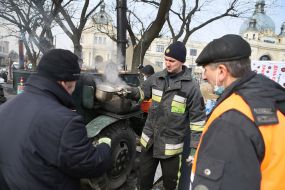 Волонтеры раздают горячие блюда беженцам на территории пункта для беженцев во Львове