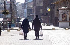 People with packages on an empty street in the center of Kyiv