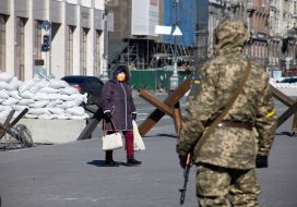 Military and woman near anti-tank hedgehogs in the center of Kyiv