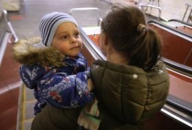 A woman with a child goes down to the subway in Kiev