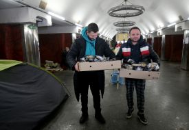 Men holding boxes of food in the subway