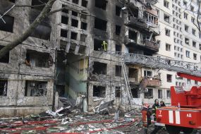 Последствия пожара после попадания снаряда в жилой дом в Киеве