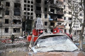 Последствия пожара после попадания снаряда в жилой дом в Киеве