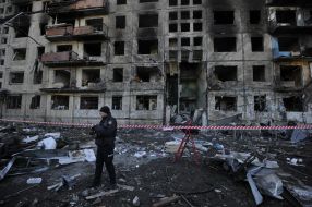 Последствия пожара после попадания снаряда в жилой дом в Киеве