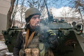 Ukrainian serviceman and Ukrainian military equipment on the street in Kharkiv