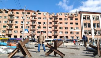 Anti-tank hedgehogs on the background of a building damaged by the blast in Kiev