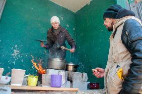 Woman preparing food on the street in Kharkiv