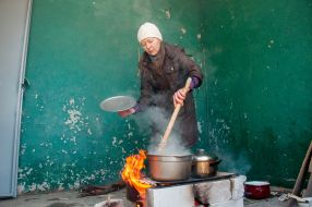 Woman preparing food on the street in Kharkiv