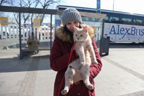 A woman holds a cat in her arms at the bus station in Lviv