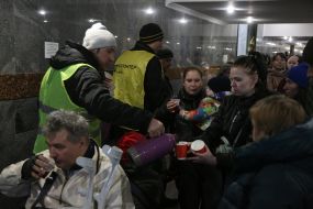 Volunteers pour tea to IDPs at the train station in Lviv