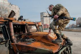 Soldier of the Armed Forces of Ukraine on a padded Russian armored car "Tiger"