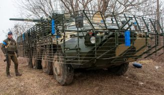 Soldier of the Armed Forces of Ukraine near the armored personnel carrier BTR-4E