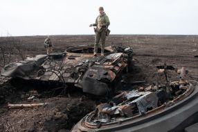 A Ukrainian soldier stands on a battered tank of the Russian occupiers