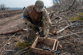 Ukrainian soldier inspects trophy cartridges in a box