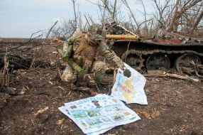 A Ukrainian soldier inspects enemy wall newspapers in the territories recaptured by the Russian occupiers
