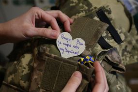 Volunteer puts heart with gratitude to the soldiers in a body armor case in a sewing shop in Stryi