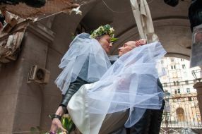 Волонтеры Настя и Антон в день своей свадьбы фотографируются на фоне разрушенных домов