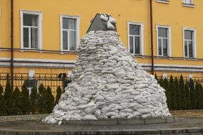 A monument to Mykhailo Hrushevsky lined with sandbags