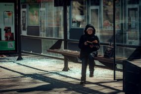 A woman with a book at a ruined bus stop